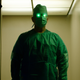 A doctor in scrubs with green glowing eyes stands in a hospital doorway in the "Queen Bee" segment of Creepshow.